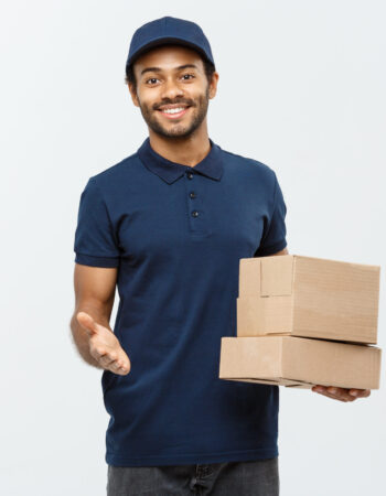 Delivery Concept - Portrait of Happy African American delivery man pointing hand to present box packages. Isolated on Grey studio Background. Copy Space.